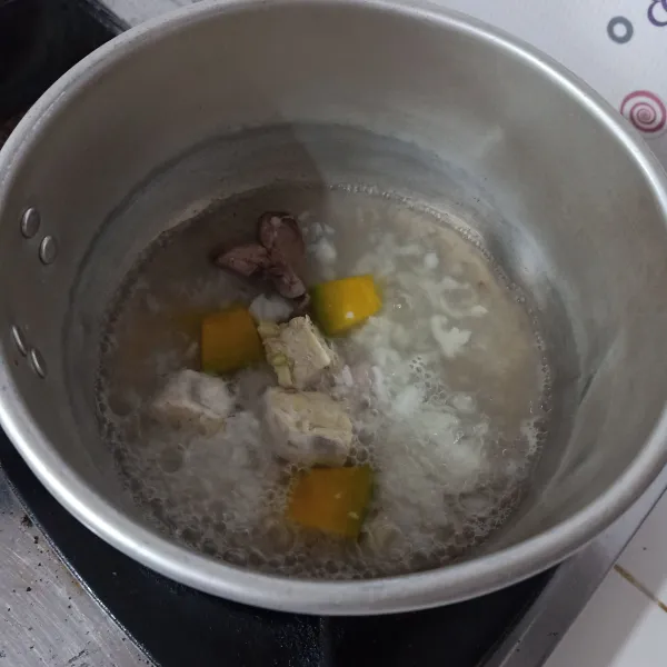 Rebus air sampai mendidih, masukkan nasi, labu, hati, tempe dan bawang, bIarkan sampai matang.