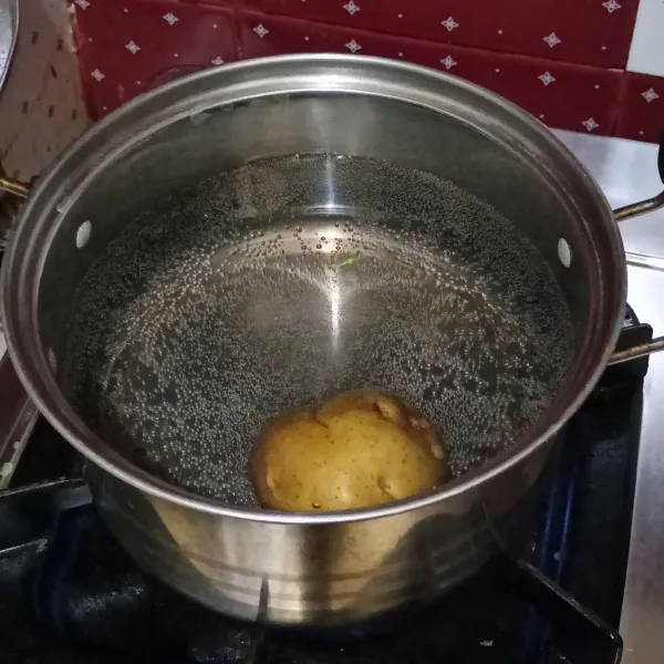 Cuci kentang lalu rebus kentang sampai empuk, lalu kupas kulitnya.