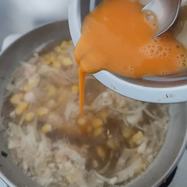 Kocok lepas telur, masukkan ke dalam kuah sup. Aduk cepat.