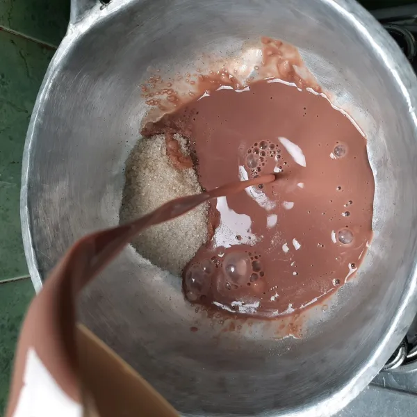 Tuangkan susu cair coklat dan tambahkan bubuk coklat lalu masak sampai susu mendidih.
