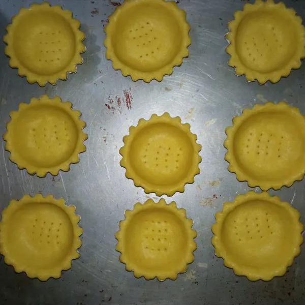 Siapkan cetakan pie, lalu oles margarin. Taruh adonan ke dalam cetakan lalu cetak menyesuaikan bentuk cetakannya. Panggang dalam oven dengan suhu 150°c