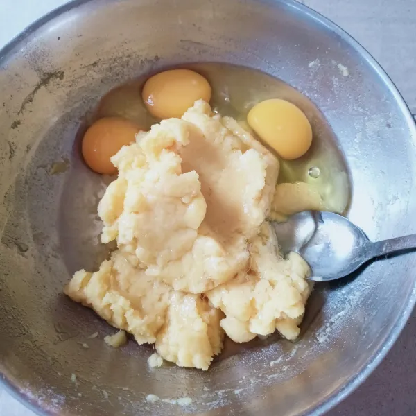 Setelah adonan dingin, tambahkan telur lalu kocok dengan whisk.