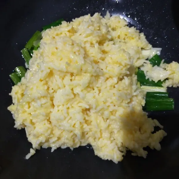 Masukkan nasi. Aduk hingga setengah matang.