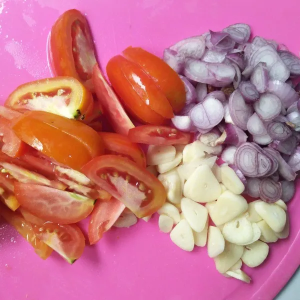 Cuci bersih bawang merah, bawang putih, dan tomat, lalu iris.