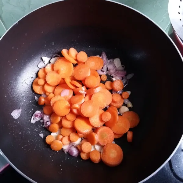 Masukkan wortel, aduk rata. Tuang air, bumbui gula, garam, lada bubuk. Tunggu wortel empuk.