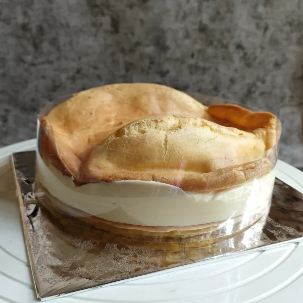 Tutup kembali dengan cake yang 1 nya lagi sambil ditekan, masukkan dalam lemari es agar set, keluarkan dari lemari es lalu tabur dengan gula halus dan hias sesuai selera.