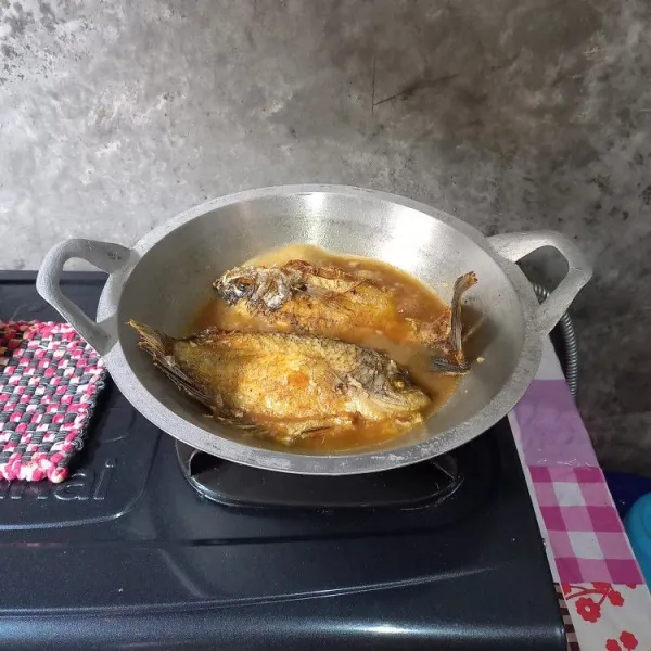 Masukkan ikan yang sudah digoreng. Masak dengan api sedang sampai air menyusut.