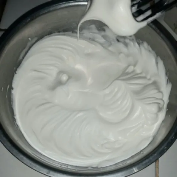 Kocok putih telur hingga berbusa, tambahkan cream of tart dan gula bertahap. Kocok dengan kecepatan paling tinggi hingga tahap soft peak.