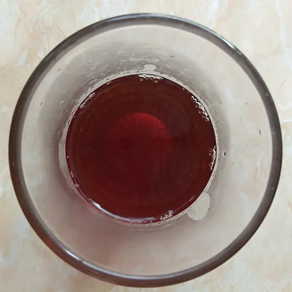 Dalam tiap gelas saji, tuang 50 ml air larutan gula.  
Masukkan juga 100 ml air teh.