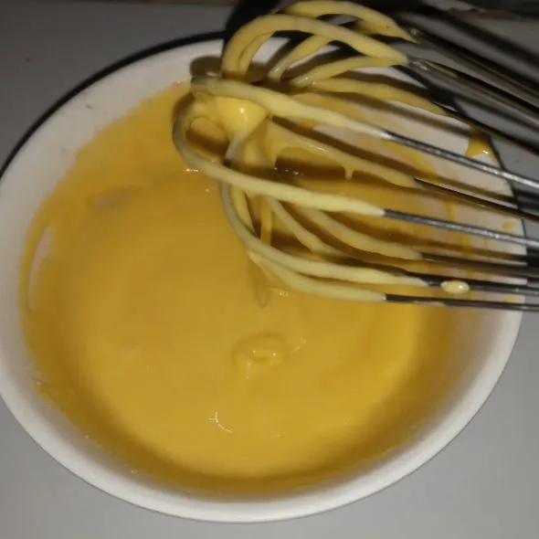 Kocok lepas kuning telur, tambahkan minyak, susu cair, dan tepung terigu, lalu aduk rata dan sisihkan.