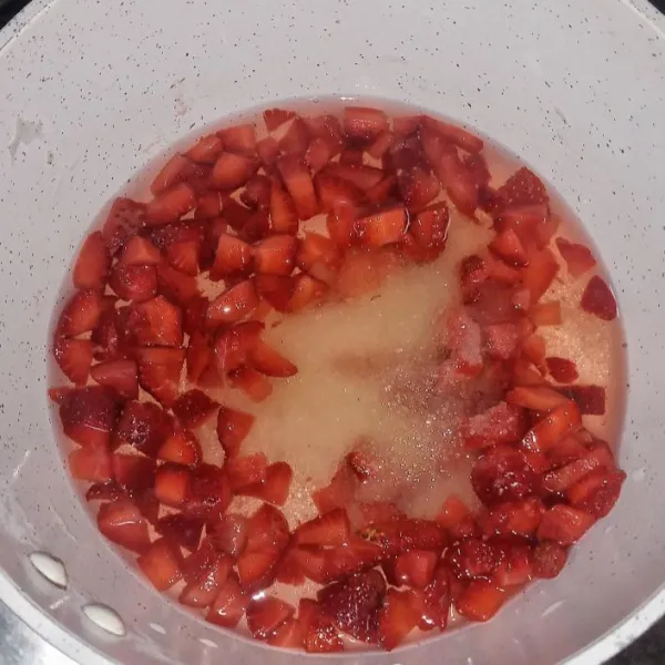Kemudian potong kecil-kecil buah strawberry. Campur bersama gula pasir dan air dalam panci.