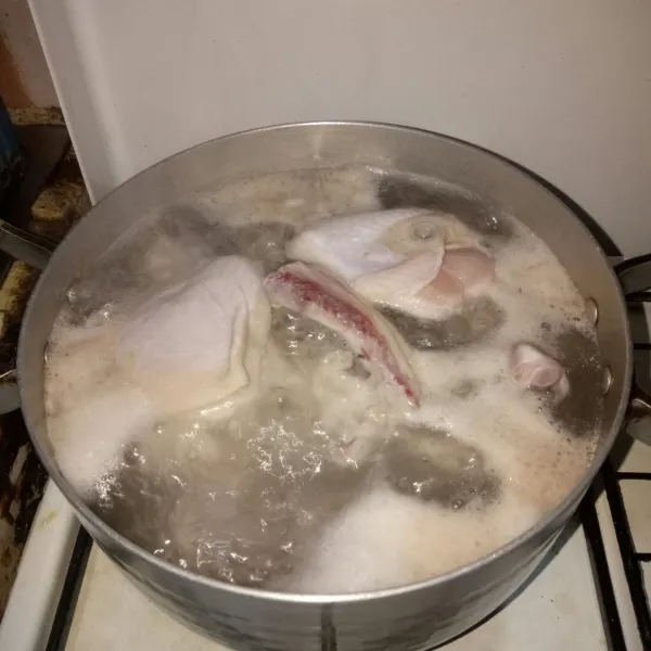 Cuci bersih ayam, lalu rebus selama 15 menit untuk menghilangkan kotoran.