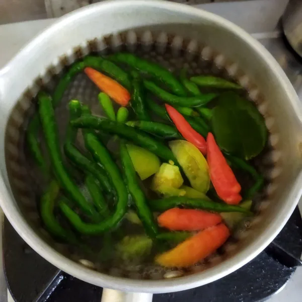 Rebus cabai, bawang, daun jeruk, dan tomat hijau sampai layu.