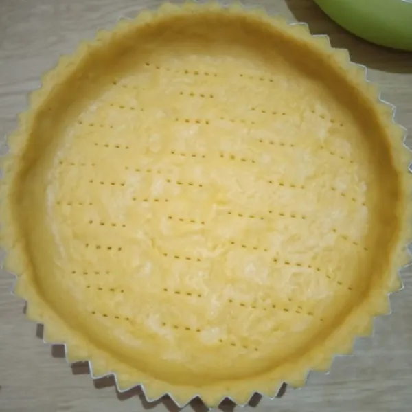 Ambil 3/4 bagian adonan taruh di loyang pie, ratakan, tusuk2 dengan garpu, sisihkan.