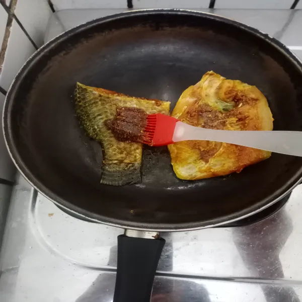 Panaskan teflon. Bakar ikan di atas teflon dengan api sedang, lalu beri bumbu oles.