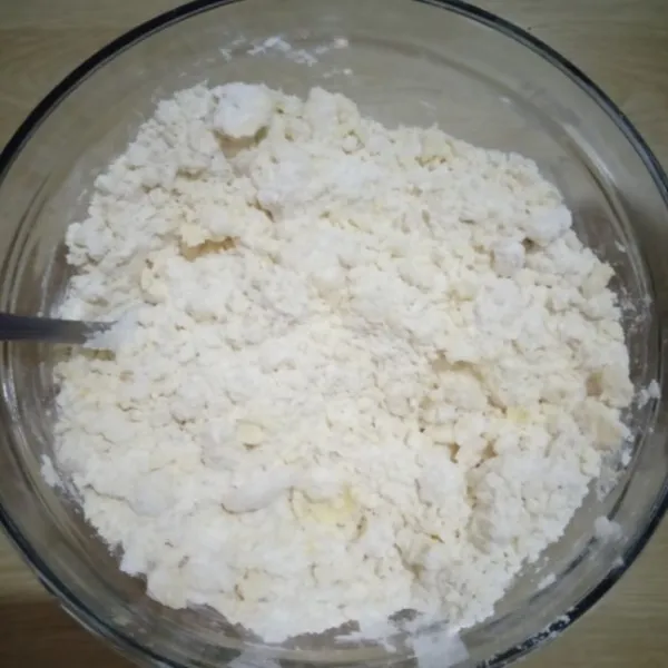 Dalam wadah campur tepung dengan butter dingin, aduk dengan sendok sampai bergerindil.