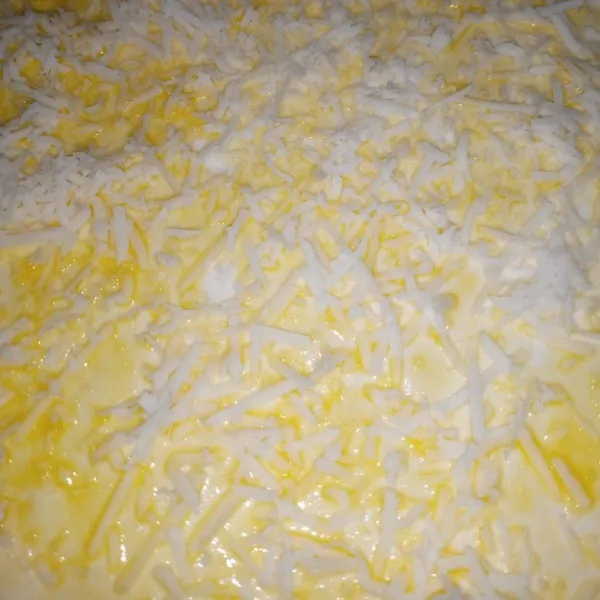 Taburkan parutan keju cheddar parut ke seluruh permukaan pastry.