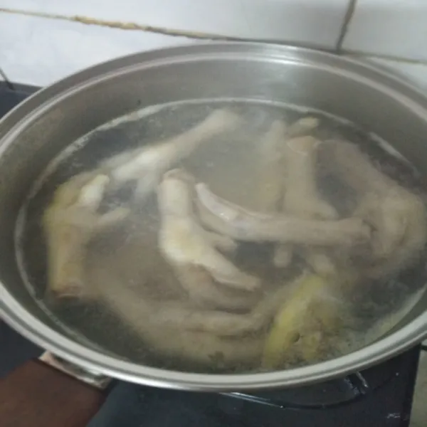 Cuci bersih ceker ayam, rebus hingga setengah matang.