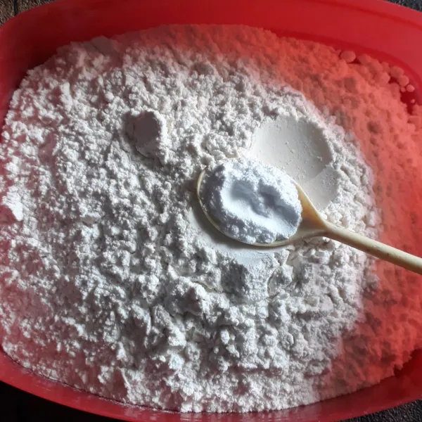 Tambahkan baking powder dan vanili bubuk ke dalam tepung terigu lalu aduk rata.