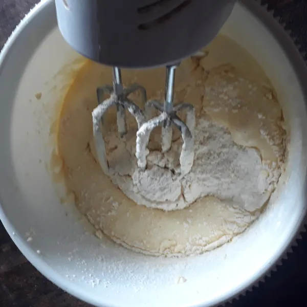 Masukkan tepung terigu sedikit demi sedikit sambil dikocok dengan kecepatan rendah asal tercampur rata saja.