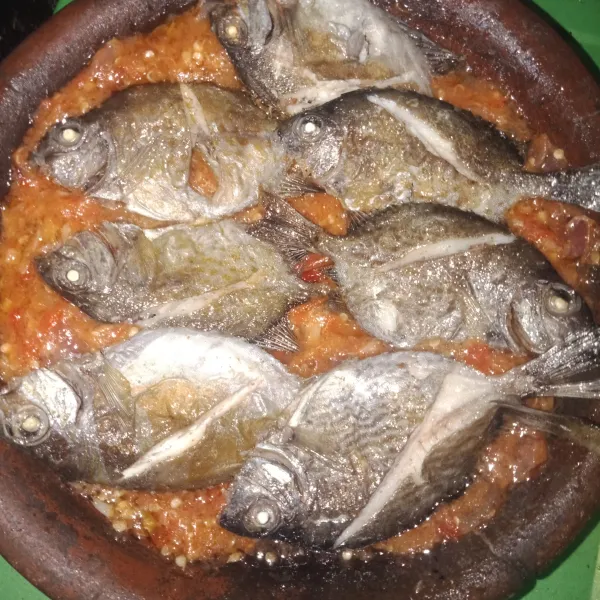 Susun ikan di atas cobek sambal.