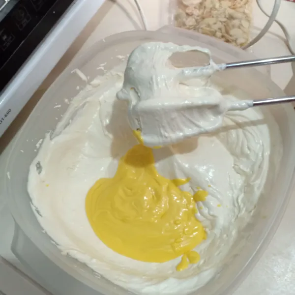 Tambahkan margarin cair, mixer sebentar saja. Kemudian aduk balik menggunakan spatula.