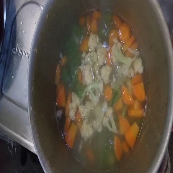 Masukkan tumisan bawang putih ke dalam rebusan daging. Tambahkan juga kembang kol dan wortel. Masak sampai sayuran lunak.