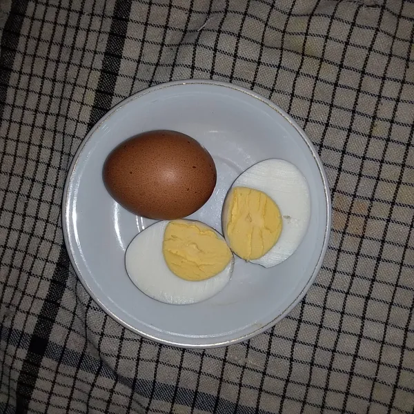 Rebus telur hingga matang. Belah menjadi 2 bagian.