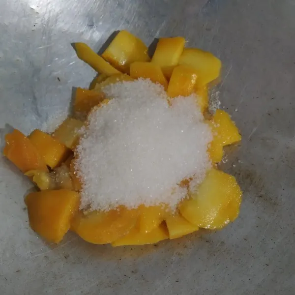 Masukan mangga ke dalam wajan. Tambahkan gula dan garam, kemudian masak dengan api sedang.