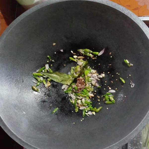 Tumis Laos dan daun salam serta irisan bawang merah, bawang putih dan cabai rawit hingga harum.