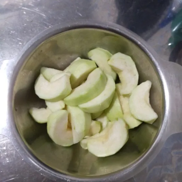 Kupas jambu, lalu potong-potong dan buang bijinya.