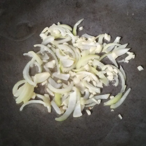 Tumis bawang putih dan bawang bombay hingga layu.
