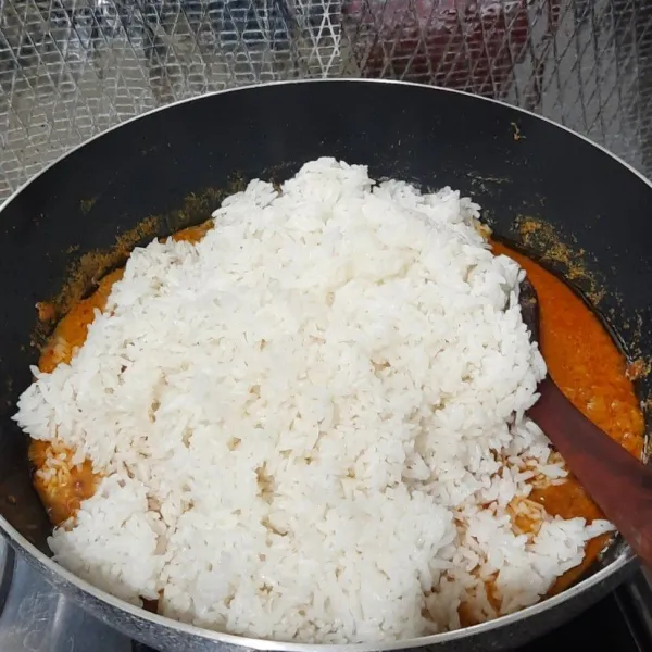 Setelah 15 menit masukkan beras aron ke dalam kuah ayam tadi (boleh menambahkan air bila dirasa kurang) aduk hingga rata, masak dengan api kecil hingga air menyusut, koreksi rasa.