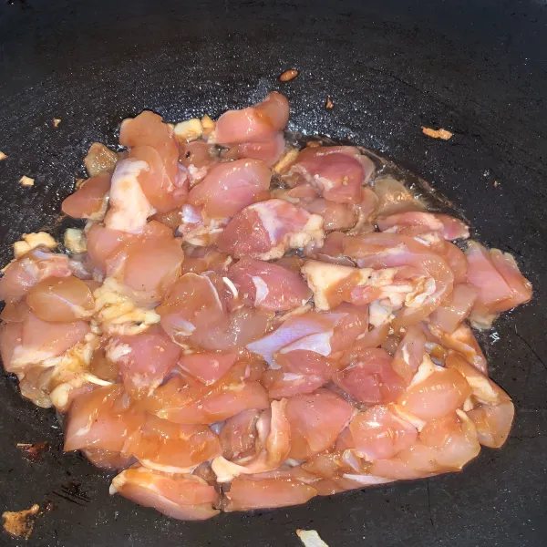 Masukkan ayam yang sudah dimarinasi sekitar 30 menit, lalu aduk hingga ayam berubah warna.