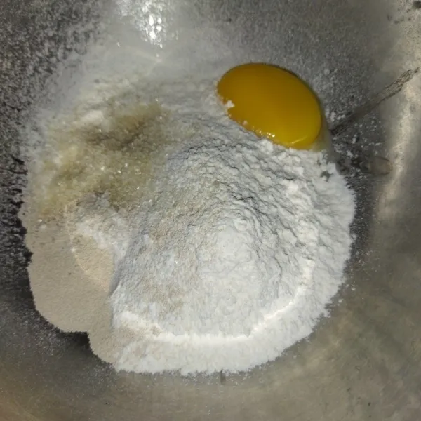 Siapkan wadah, masukkan tepung terigu, ragi instan, kuning telur, gula pasir.