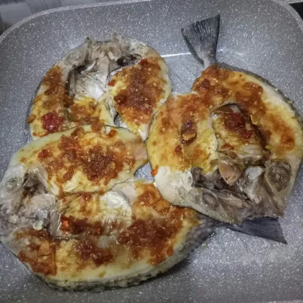 Lalu, oleskan bumbu ke semua sisi ikan. Tuang nanas di atasnya, dan masak sampai ikan matang sempurna.
