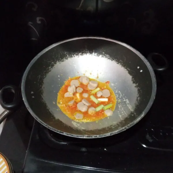 Masukkan baso dan batang daun bawang, aduk rata.