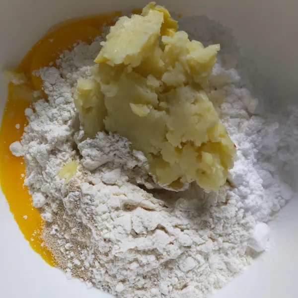 Siapkan wadah, masukkan tepung terigu, kentang, ragi instan, gula halus (1) dan kuning telur.