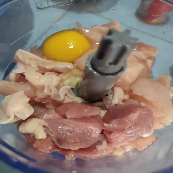 Potong dadu daging ayam dan sapi yang sudah di bersihkan untuk memudahkan proses penghalusan, kemudian masukkan ke dalam chopper. Tambahkan 1 butir telur, lalu haluskan.