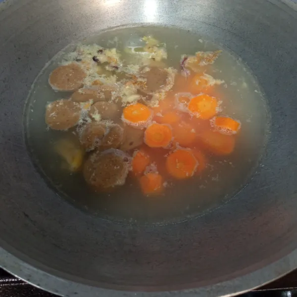 Tambahkan irisan bakso dan wortel.