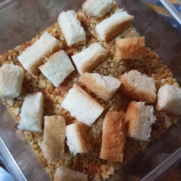 Gunting pinggiran roti tawar di atas biskuit (bisa skip ya)