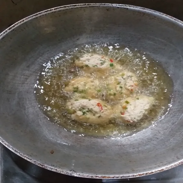 Panaskan minyak menggunakan api sedang, ambil 1 sdm adonan tahu lalu goreng hingga kecoklatan dan matang, angkat dan tiriskan