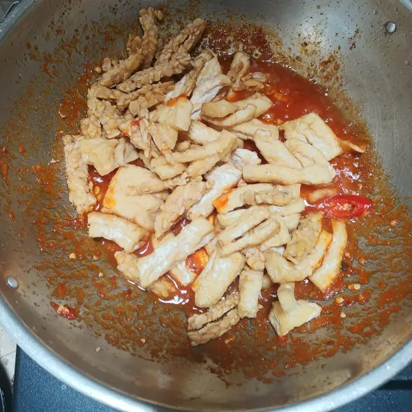 Masukkan irisan cabe merah, bumbui dengan gula, garam dan kaldu bubuk. Aduk hingga rata lalu masukkan tahu dan tempe yang sudah di goreng.