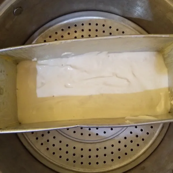 Tuang 1/2 adonan ke dalam loyang (8x20x7) yang sudah diolesi dengan margarin (sebaiknya alasi dengan kertas roti, agar lebih rapi saat dikeluarkan dari loyang). Kukus selama 10 menit menggunakan api sedang cenderung kecil (agar kue tidak bergelombang).