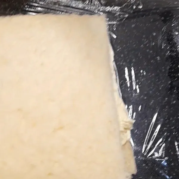 Tutup dengan roti lainnya, bungkus dengan plastic wrap. Tandai plastik arah yang akan dipotong dangan spidol agar tidak salah memotong. Dinginkan di freezer kurang lebih 2 jam.