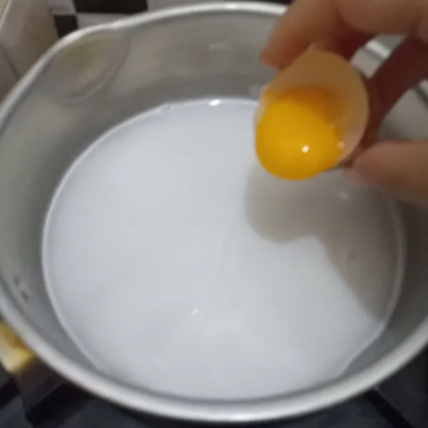 Tambahkan 1 butur kuning telur dan essens vanila, aduk rata