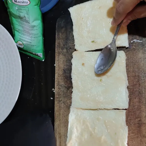 Oleskan mayonnaise thousand island di permukaan roti.