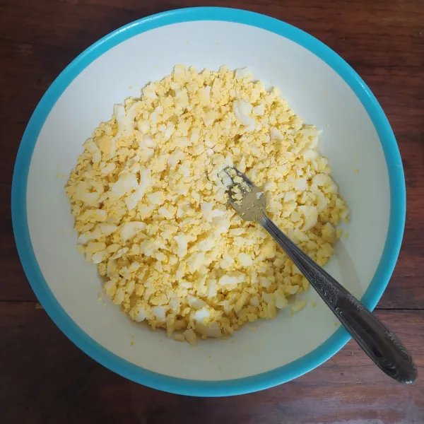 Hancurkan telur rebus dengan garpu.