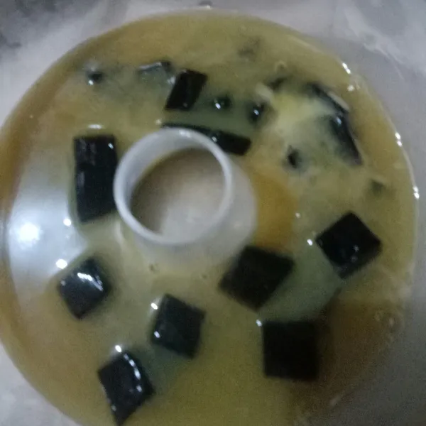 Tuangkan sebagian puding gula merah, biarkan sedikit berkulit