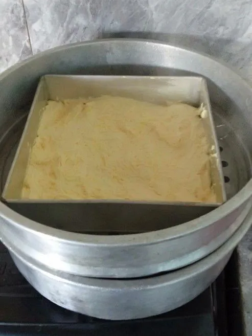 Kemudian taruh dalam loyang ukuran 22x22 yang telah di olesi margarin, kukus dalam panci yang telah dipanaskan sebelunya, kukus hingga matang kurang lebih 15 menit, kemudian dinginkan.